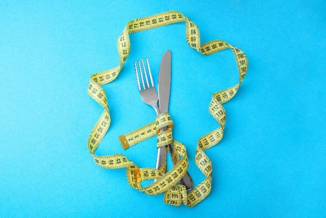 סכום ועליו סרט מדידת היקפים, מסמל ירידה במשקל